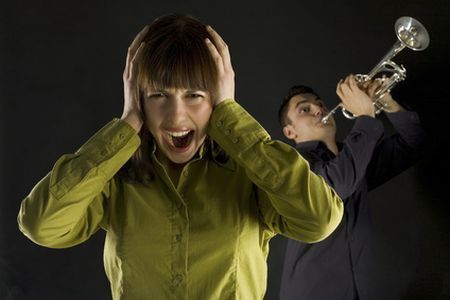 Trumpet man standing behind the woman. inquinamento acustico