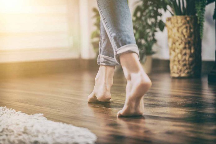 Riscaldamento a pavimento Donna cammina a piedi nudi su pavimento riscaldato