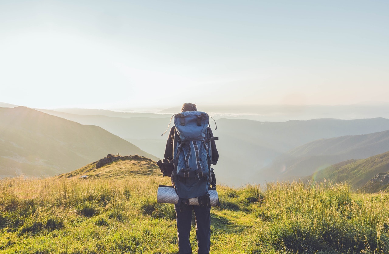 uomo in piedi davanti ad un paesaggio di montagna