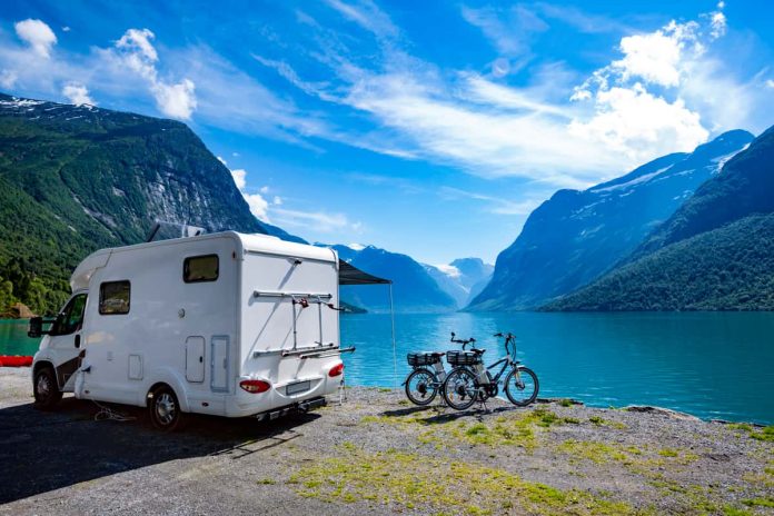 camper con vista camper sulla riva di un lago con bici