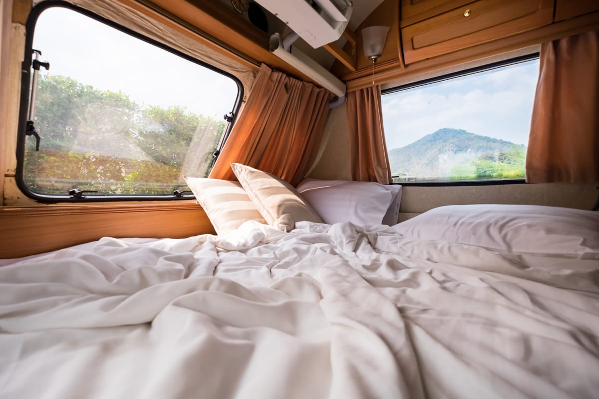 Letto di un camper con cuscini e vista 