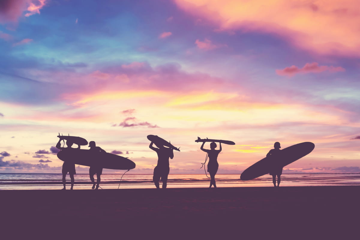 cinque ragazzi con tavole da surf sulla spiaggia