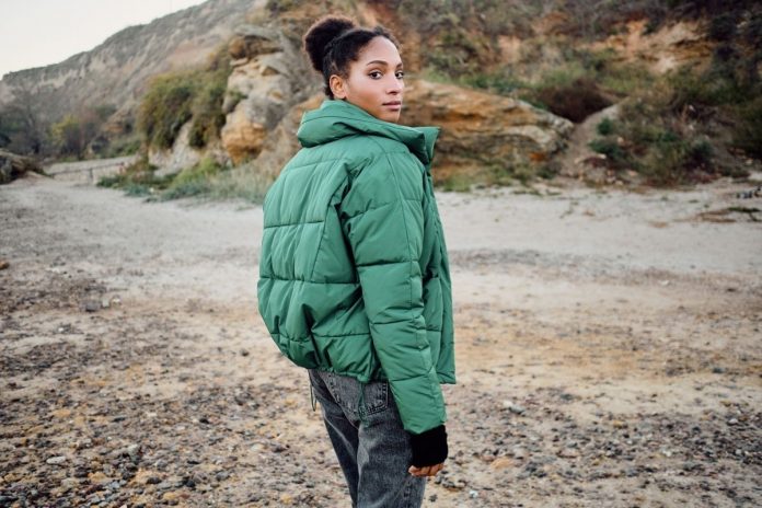 Ragazza con piumino verde sostenibile Ragazza con piumino verde