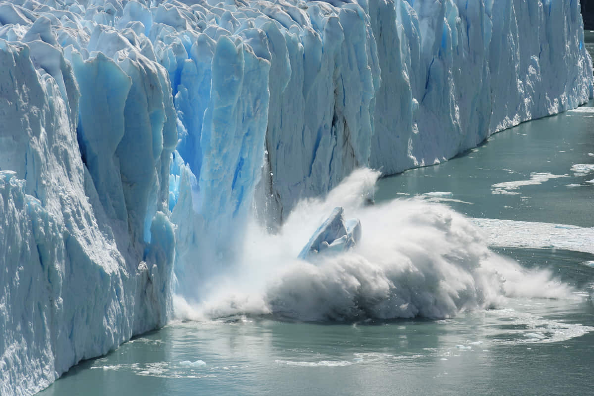 grosso blocco di ghiaccio cade in acqua da parete ghiacciata