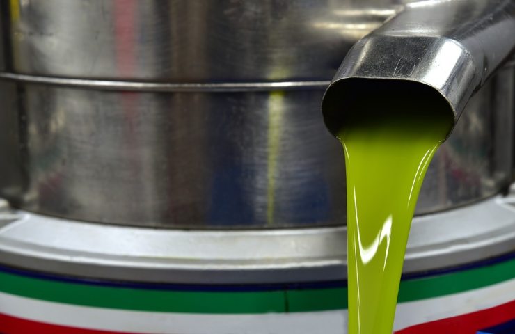 Dell'olio d'oliva versato da un contenitore in latta