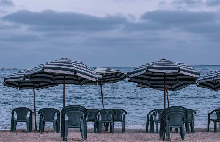 Ombrelloni aperti in spiaggia sotto ad un cielo nuvoloso