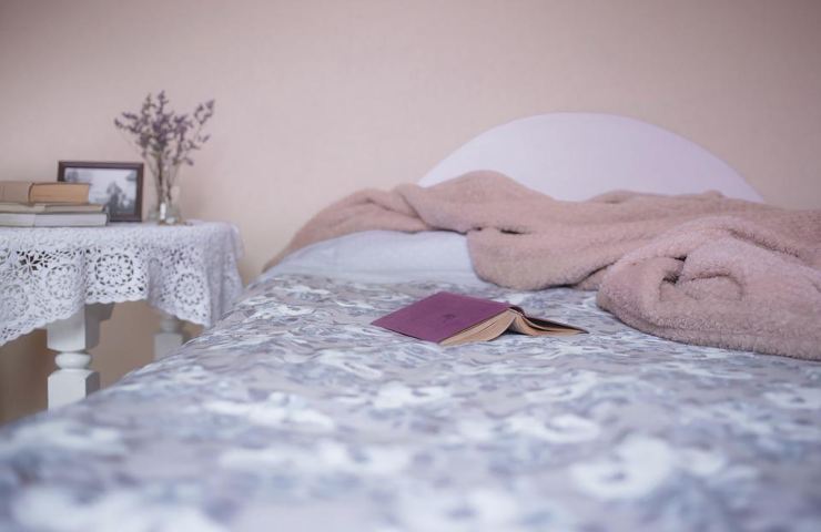 Un letto con un libro ed una copertina su