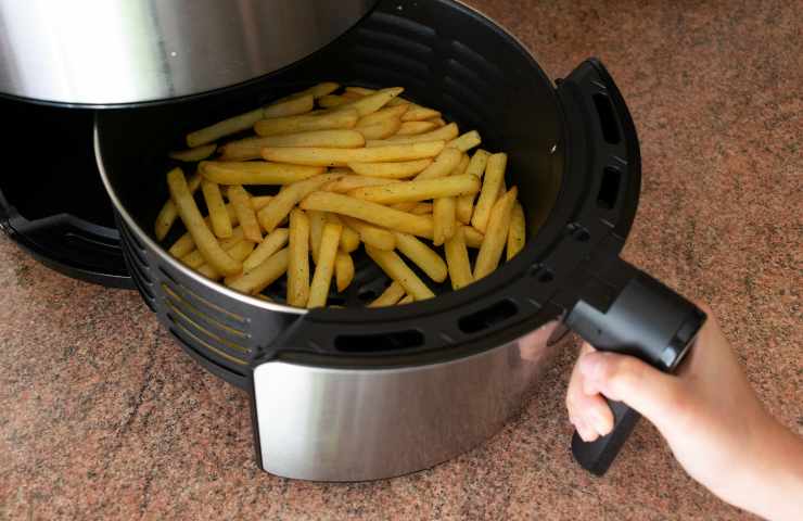 Macchina da cucina per friggitrice ad aria bianca con tavolo in legno per  patatine fritte su una cucina ai generativa