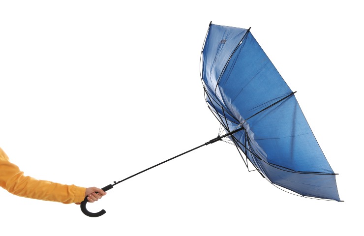 Una persona regge un ombrello rotto