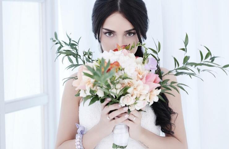 Una sposa tiene tra le mani il suo bouquet