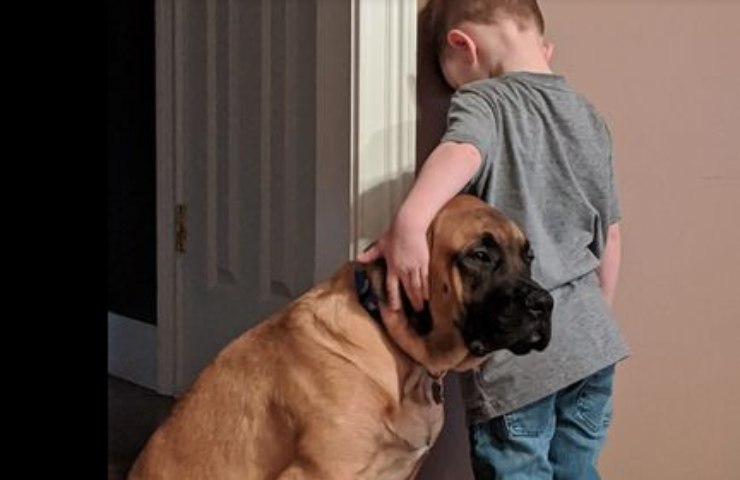 Un bambino in punizione con il suo cucciolone accanto