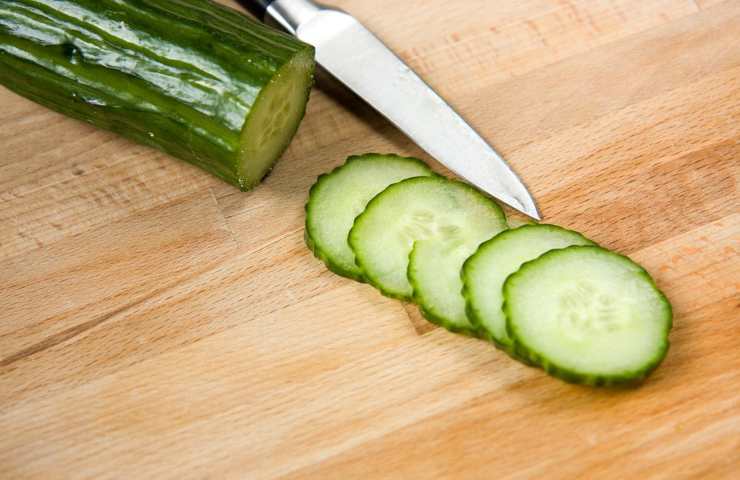 Una zucchina affettata su di un tagliere in legno