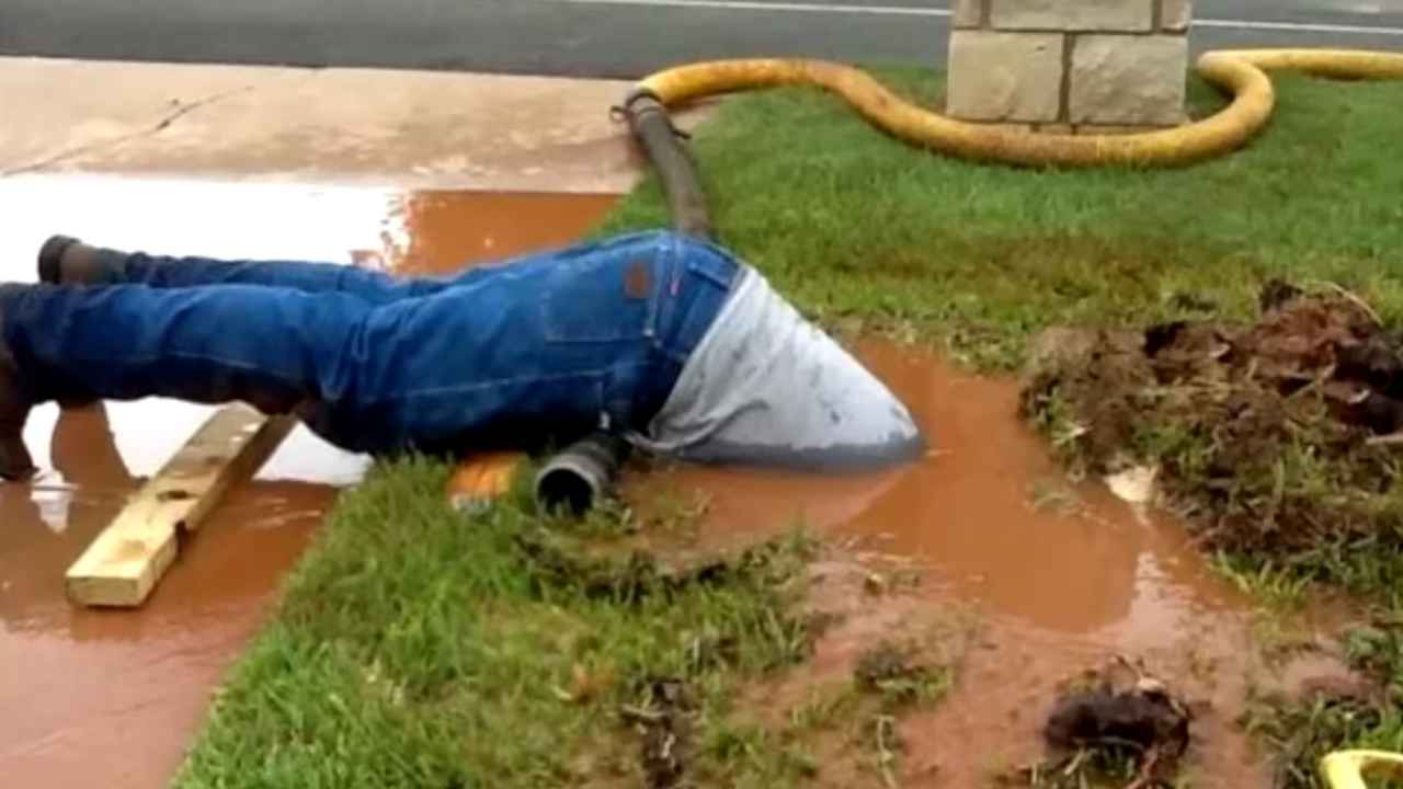 Idraulico Texas si immerge pozzanghera riparare perdita tubo