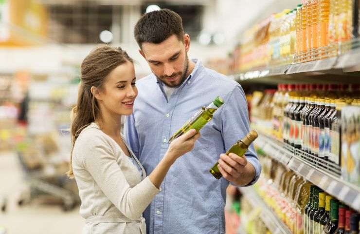 Coppia di ragazzi sceglie l'olio d'oliva da acquistare