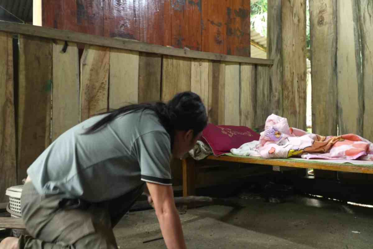 il padre con un bastone prova ad allontanare il pitone