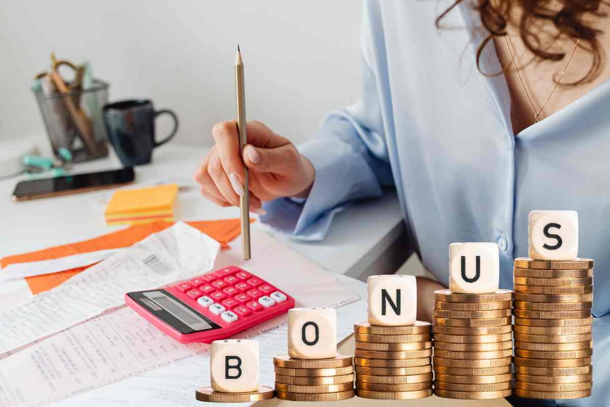 donna fa i conti con le bollette e davanti la scritta bonus